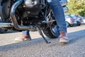 Close view shot of motorcyclist positioning the kickstand