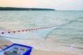 Close view of some blue fishing net floaters on the beach with boat and human while laying nets on the sea Royalty Free Stock Photo