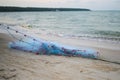 Close view of some blue fishing net floaters on the beach with boat and human while laying nets on the sea Royalty Free Stock Photo