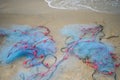 Close view of some blue fishing net floaters on the beach with boat and human while laying nets on the sea Royalty Free Stock Photo