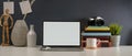 Study table with mock up laptop, stack of books, camera, supplies and decorations on white table Royalty Free Stock Photo