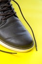 Close View of Synthetic Leather Brown Shoe with Yellow Background Royalty Free Stock Photo