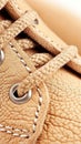Close view of tan leather shoe laces, showcasing intricate stitching and texture, emphasizing quality craftsmanship and