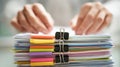 Close view of two hands organizing a stack of colorful documents with binder Royalty Free Stock Photo