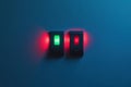A close view of two light switches mounted on a wall. The green switch is illuminated, Royalty Free Stock Photo