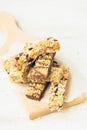 Close view of various homemade granola bars with nuts, seeds, dark chocolate, honey and berries over a wooden board Royalty Free Stock Photo