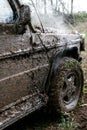 Close of view of a very muddy car after off road driving through the dirt and mud.