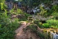 Close view of wooden bridge over stream with waterfall.