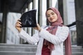 Close waist up portrait of smiling Muslim woman doctor holding an x-ray.