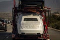 Close upon white wrapped auto on an Auto Transport Carrier on Freeway