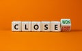 Close won or lost symbol. Turned the wooden cube and changed words Close won to close lost. Beautiful orange background, copy