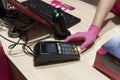 Closeap at hand at pink medical glove paying with paying machine at the shop,