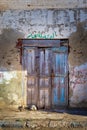 Closed abandoned wooden weathered door and shabby old grunge wall Royalty Free Stock Photo