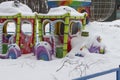 Closed amusement park in winter, a multi-colored carousel covered with a thick layer of snow. City leisure park for children, Royalty Free Stock Photo