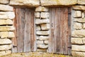 Closed ancient doors in rough stone wall