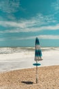 Closed beach umbrella on a beach on the Adriatic Sea in Italy