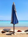 Closed beach umbrella and turquoise waters of the Red Sea in the Sinai Peninsula. Chill out and relaxation Royalty Free Stock Photo