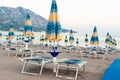 Closed beach umbrellas and sunbeds on a on an empty sandy beach early morning. Holidays on the Adriatic Sea. Montenegro Royalty Free Stock Photo
