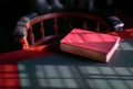 Closed bible on the edge of table with chesterfield chair at the background