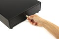 Closed black cash drawer and hand with key in lock, white background, concept security of banking safe deposit