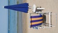 Closed Blue Beach Umbrella with Chair