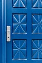 Closed blue door with pattern and aluminium handle