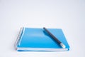 Closed blue notebook on the table. On the notebook is a black pencil. Royalty Free Stock Photo