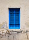 Closed blue window with shutters in the window opening of an old building or house Royalty Free Stock Photo