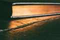 A closed book with a Golden edge on an old black wooden table Royalty Free Stock Photo