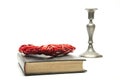 Closed book on the table. Ancient Bible. candlestick. On white background. Red heart.