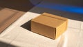 Cardboard Box on Textured Fabric with Dramatic Sunlight and Blue Light Reflections brown Royalty Free Stock Photo