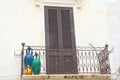 Closed brown door with green, blue and yellow vases on a balcony in south Italy Royalty Free Stock Photo