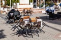 Closed cafe terrace due to coronavirus pandemic with old menu table and packed chairs with tables Royalty Free Stock Photo