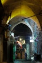 Closed counters of merchants and the Georgian cross. Dark nightly narrow streets of the old city,