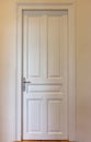 Closed door on house wall background. Interior retro white tall door, front view