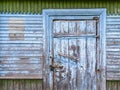 Closed door on blue painted weathered wooden barn wall Royalty Free Stock Photo