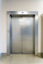 Closed elevator doors. Shiny metal elevator doors in a new modern elevator. An empty hall on the floor of an office building Royalty Free Stock Photo