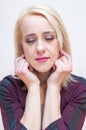 Closed eyes blonde woman holding earlobes with fingers Royalty Free Stock Photo