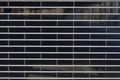 closed folding gate of metal fence tiles at parking garage shows out of business resulting from broke and insolvency