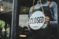 Closed. friendly waitress wearing protection face mask turning open sign board on glass door in modern cafe coffee shop, cafe rest Royalty Free Stock Photo