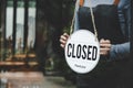 Closed. friendly waitress wearing protection face mask turning open sign board on glass door in modern cafe coffee shop, cafe rest