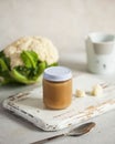 Closed glass jar with baby food smoothie puree on a wooden board. Layout Baby food concept, first feeding.