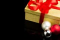 Closed Golden Box With Red Ribbon and Three Baubles