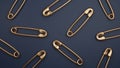 Closed golden sewing safety pins on dark blue background. 3D rendering.