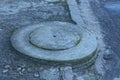 Closed gray concrete sewer manhole near the road with asphalt Royalty Free Stock Photo
