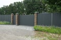 Closed gray metal gates and a long iron fence