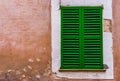 Closed green window shutter and rustic wall of mediterranean house Royalty Free Stock Photo