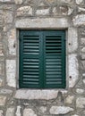 Closed green window with shutters in the window opening of an old building or house Royalty Free Stock Photo