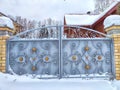 closed iron gate on a gray brick wall of garage outside in white snow Royalty Free Stock Photo