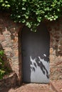 Closed iron gray door in a stone wall